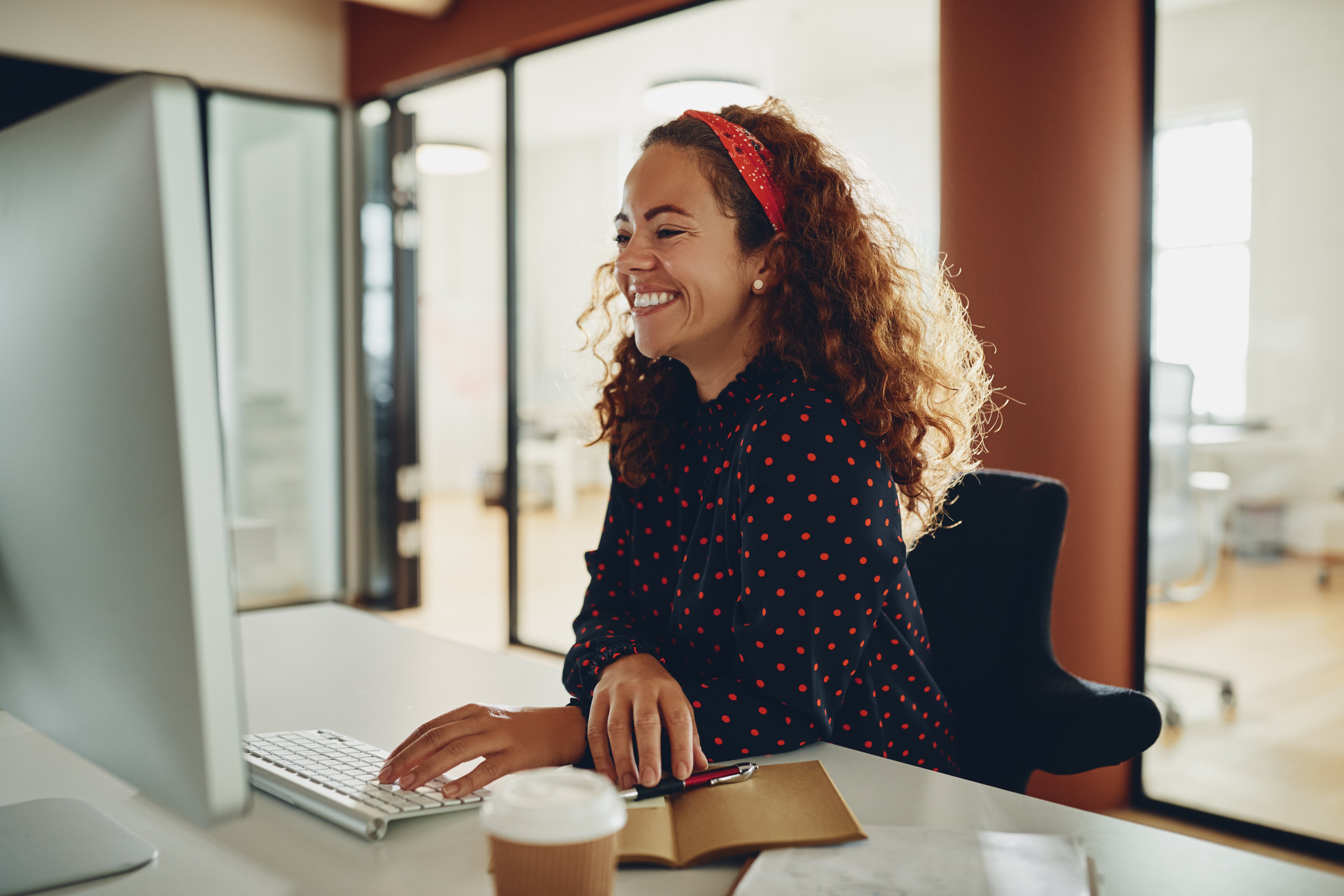 Person happy at work working on computer