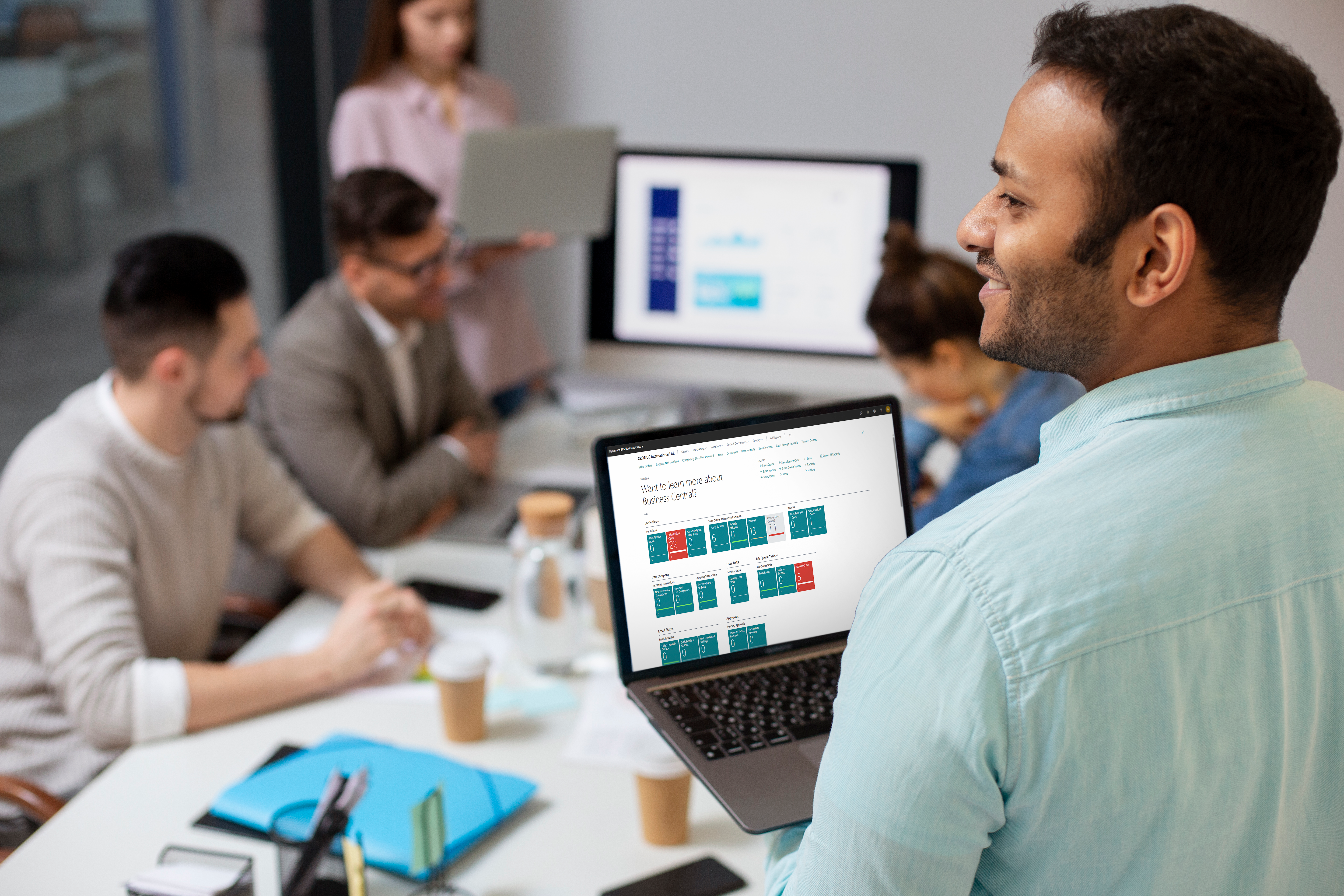 Team using Business Central on laptop and working together